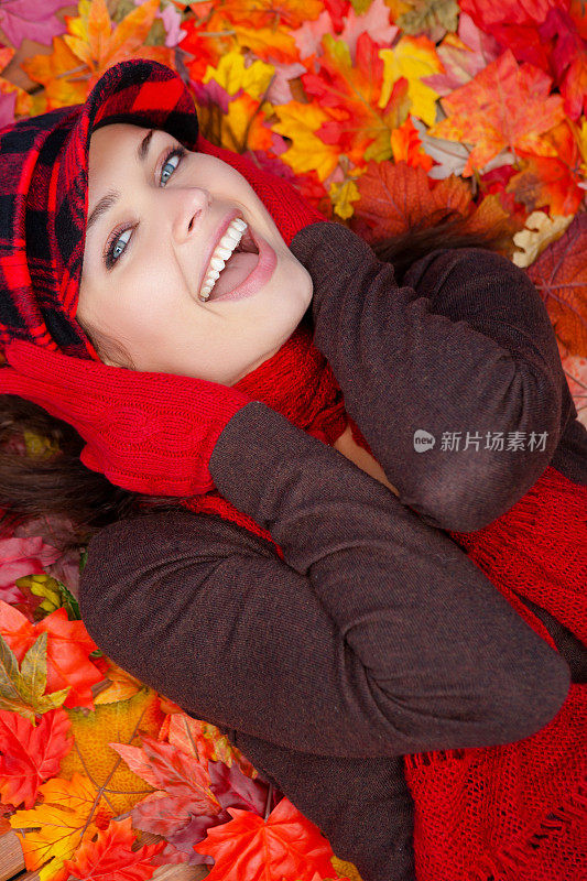 年轻女子躺在秋叶上