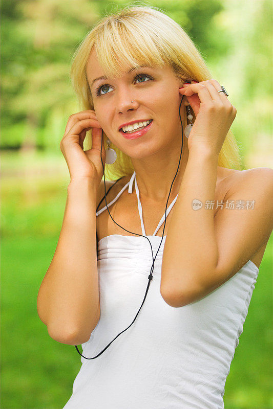 年轻的金发女性，正在听音乐