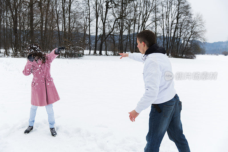 年轻人向他的女朋友扔雪球