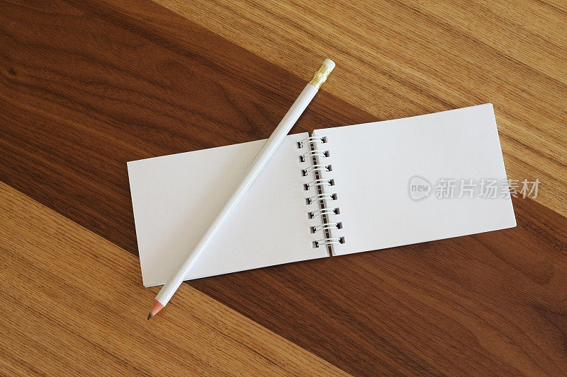 木桌上的空白螺旋式记事本和铅笔