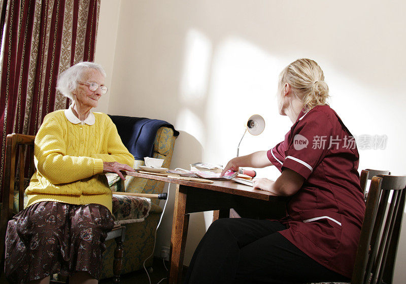 护士在养老院和一位年长的女士聊天
