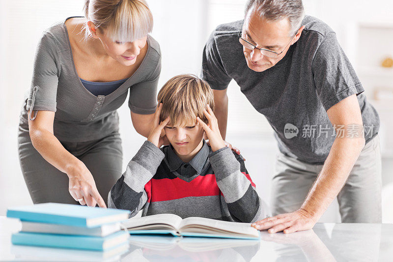 父母帮助儿子做家庭作业。