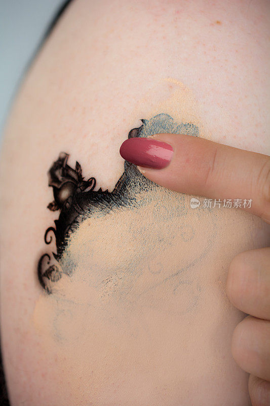 一名女子用粉底妆遮盖手臂上的纹身