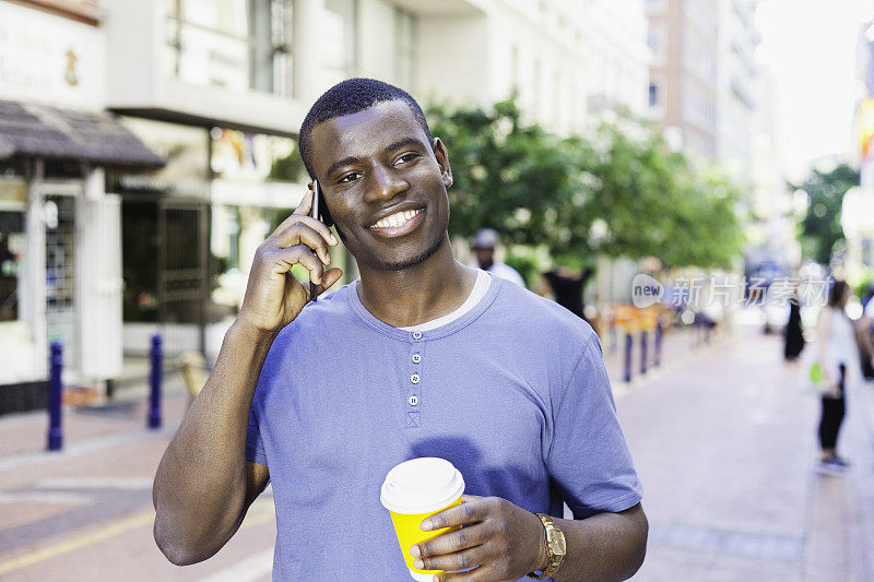 年轻的非洲人微笑着，他讲电话