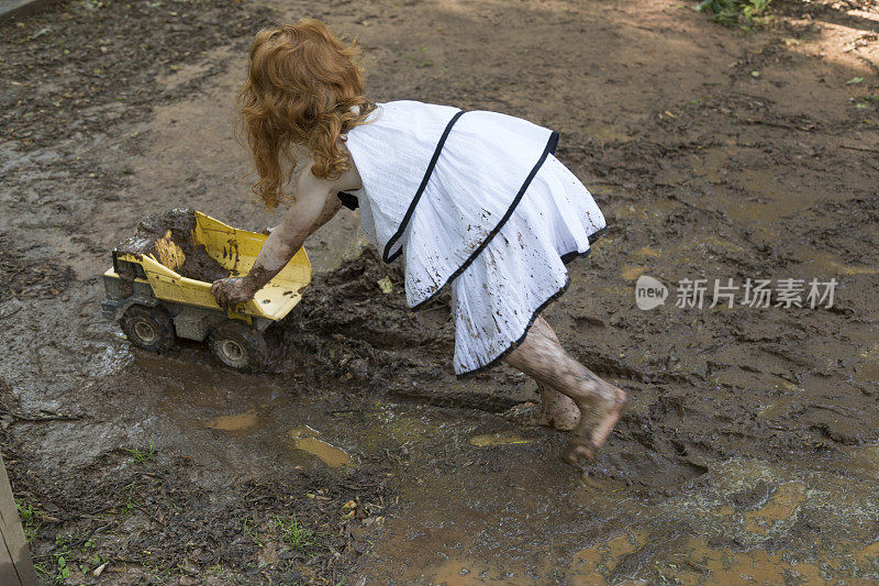 小女孩在泥里玩