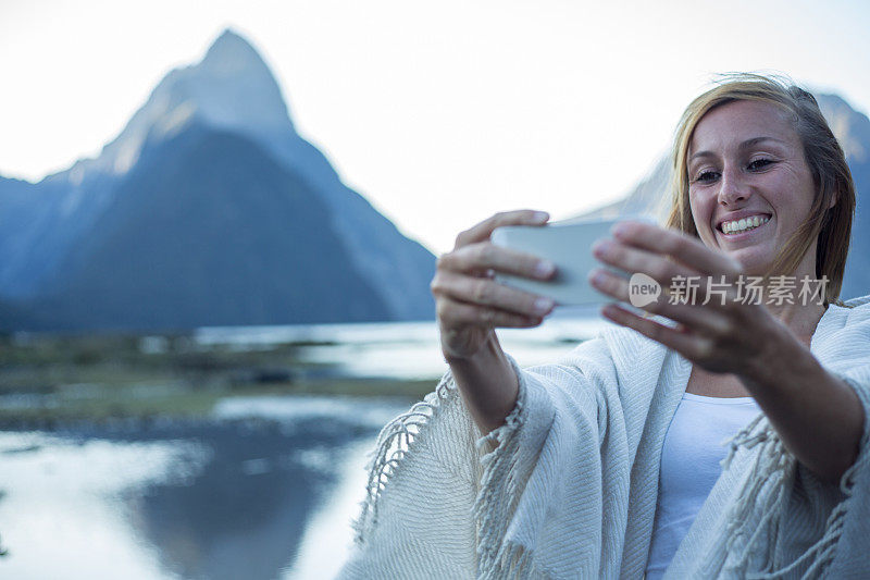 一名女子在新西兰米尔福德湾拍摄自拍照