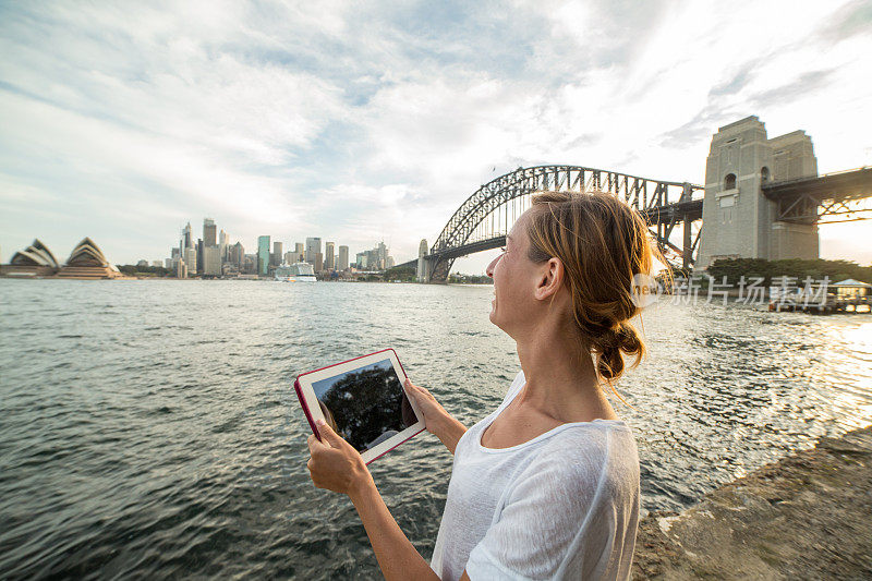 一名悉尼女子用平板电脑拍摄悉尼的天际线