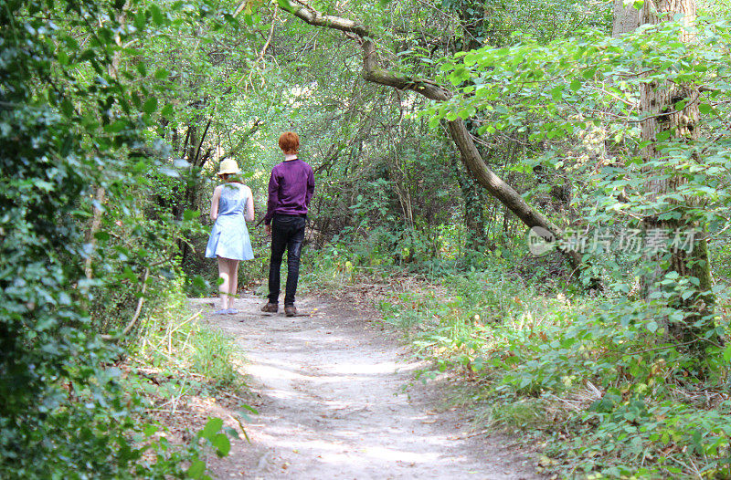男孩和女孩在林地小径上行走的画面