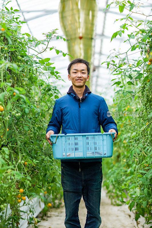 一个中年男人站在他的小温室里