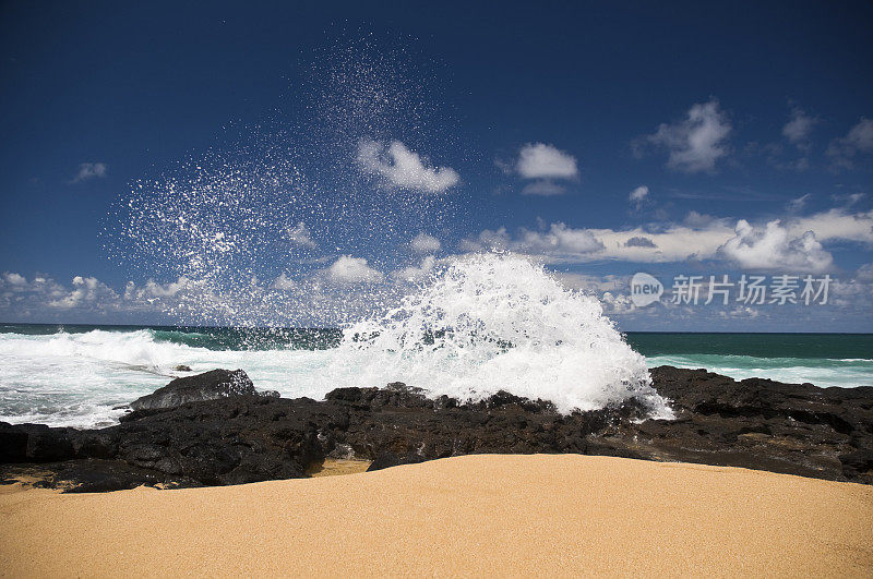 夏威夷考艾岛，海浪拍打着海滩上的岩石