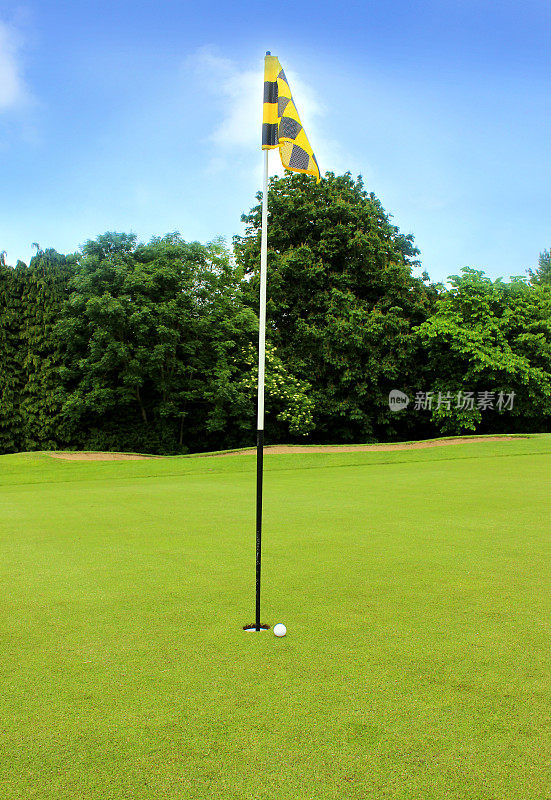 在高尔夫球场的洞内铺上绿草和旗子