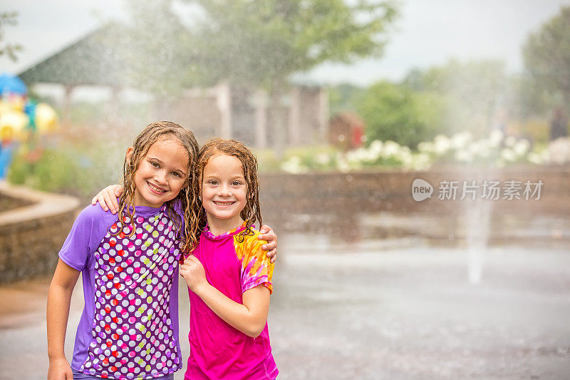 两个女孩在户外喷水池公园