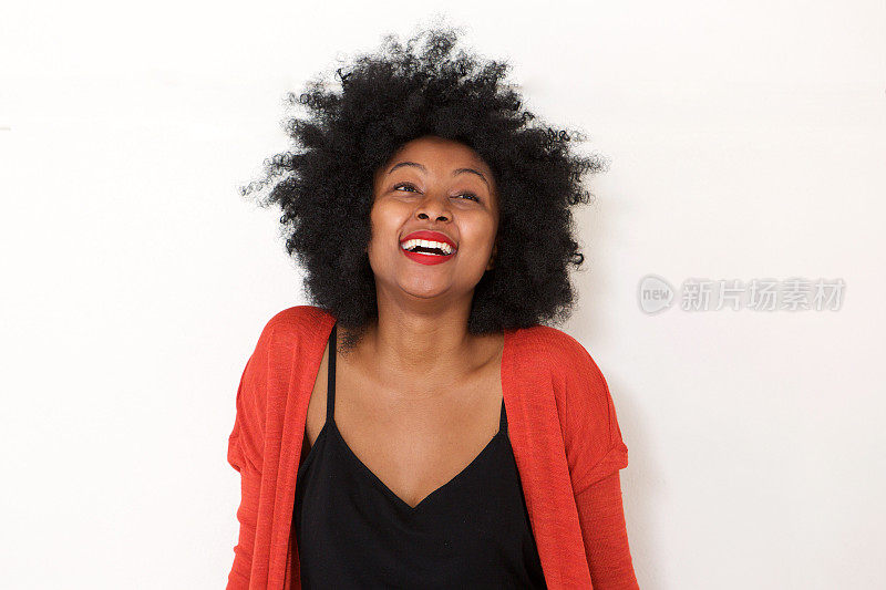 年轻的非洲妇女在白墙边笑