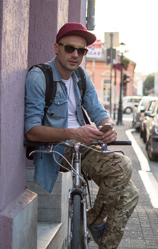 用智能手机骑自行车的帅哥