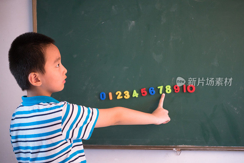 亚洲男孩站在数字黑板前