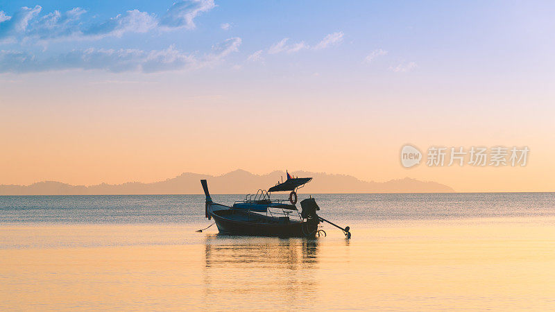 美丽的日落在热带海洋与长尾船在泰国南部