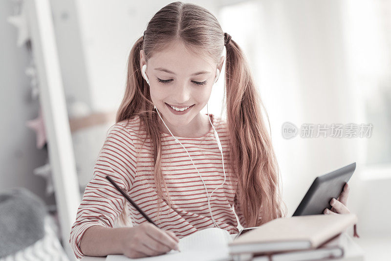 兴高采烈的女孩拿着平板电脑在写字