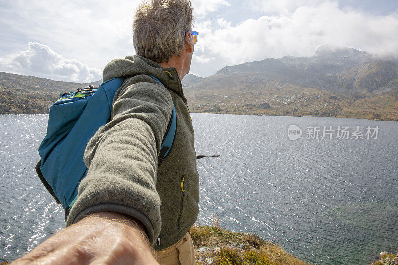 徒步旅行者探索高山垭口上的湖泊