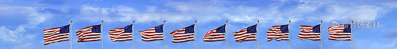 一组美国国旗在高高的旗杆上排成一行