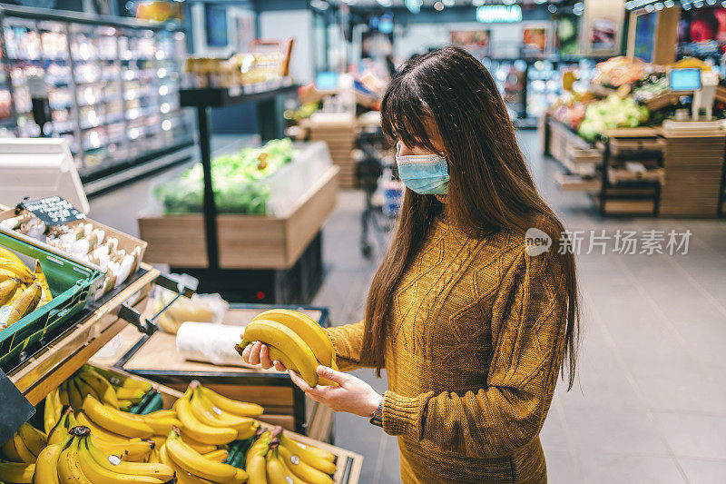 在杂货店挑选香蕉的女人