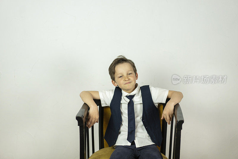 自信的小男孩坐在椅子上