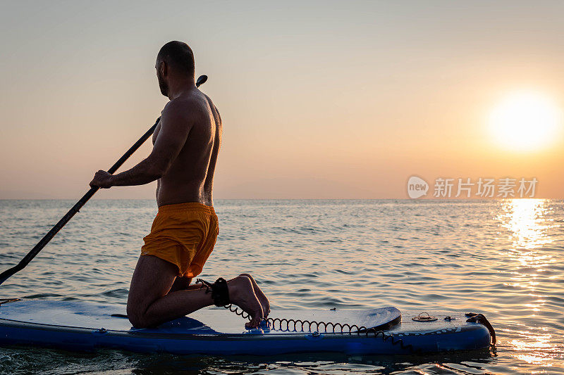 日落时男子划桨的剪影