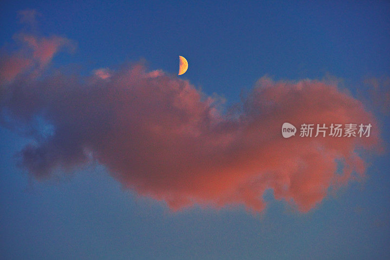 红云上挂着半月形的月亮