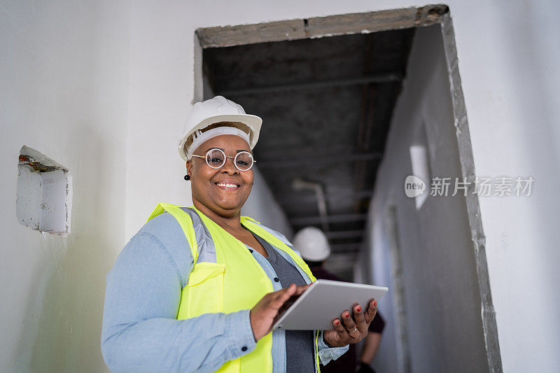 一名女性建筑工人在建筑工地使用数码平板电脑