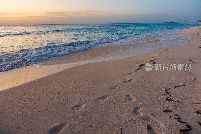 墨西哥坎昆海滩上的脚印被海浪冲走