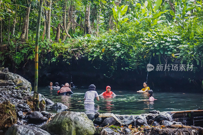 人们在丛林的河里游泳