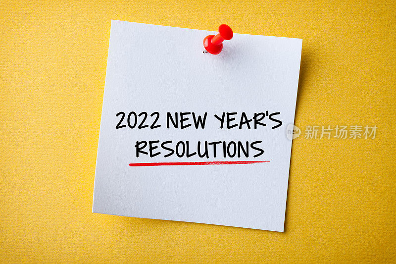 白色便利贴与新年2022决议和红色图钉黄色背景