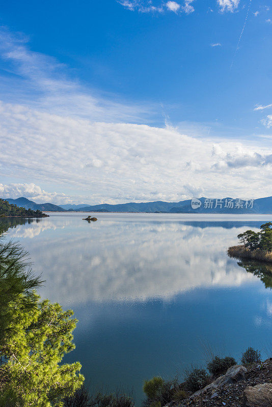 湖岸的森林，天空中的云在水面上的倒影