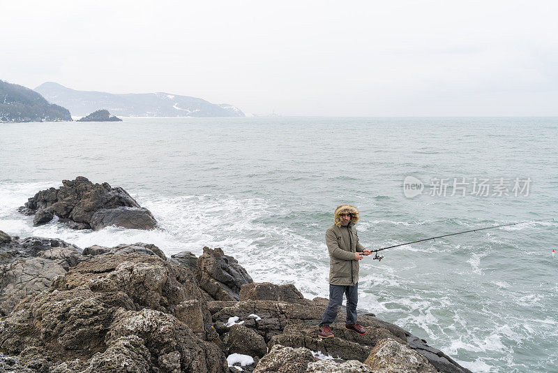 男人在黑海沿岸用钓鱼竿钓鱼