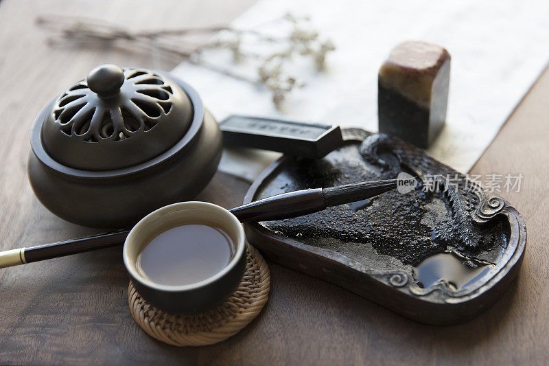中国传统的书写工具，毛笔和宣纸，砚台，印章，中国绿茶和精美的香炉