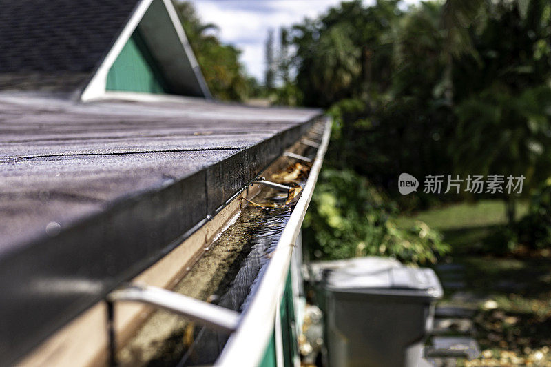 在暴风雨中，一个普通家庭屋顶上的雨槽