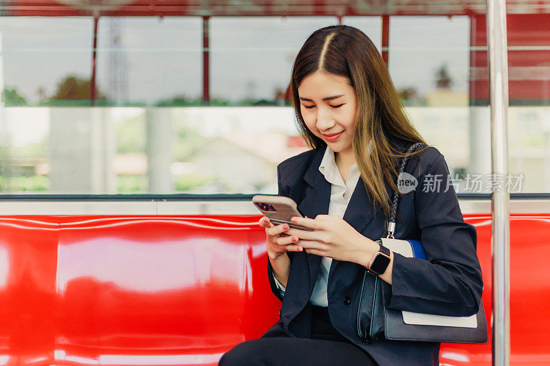 商务女性在去办公室的火车上使用智能手机。