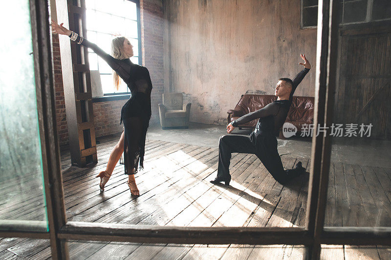 一对两名专业交际舞演员在阁楼工作室跳舞。优美的艺术表演。运动生活理念。激情与情感之舞。