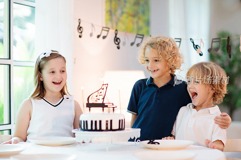 音乐和钢琴生日聚会。吃蛋糕的小孩。