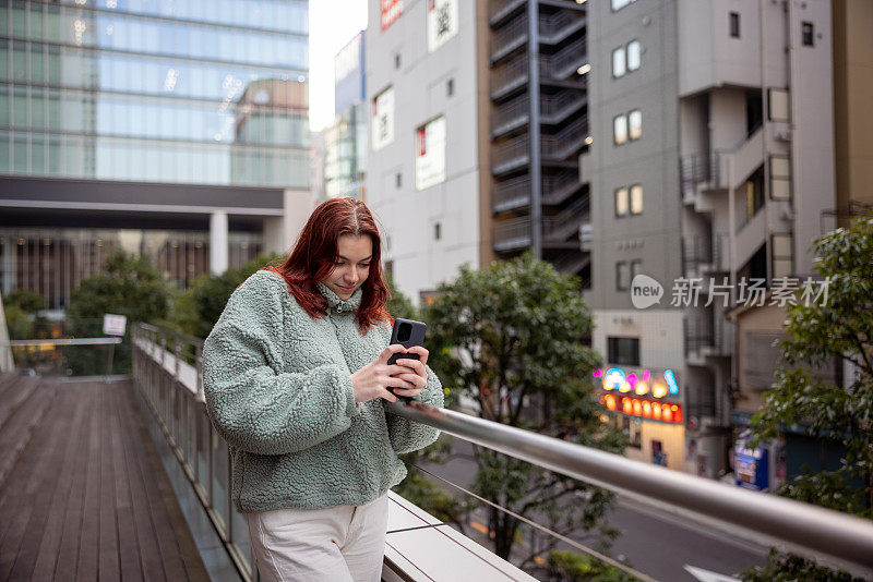 年轻女游客在城市中拍照的肖像