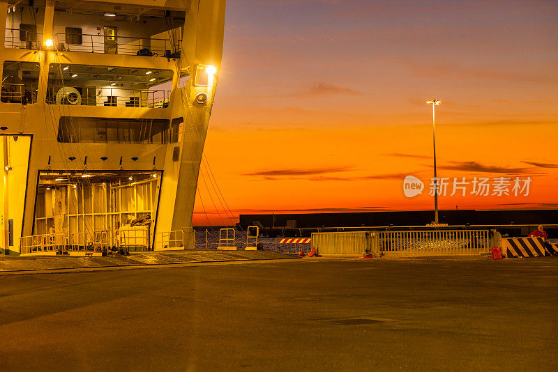 日落时分停泊在港口的灯火通明的大渡船