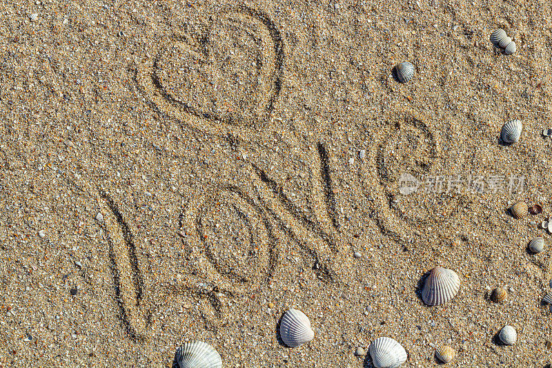 爱的讯息写在沙子上，背景为设计