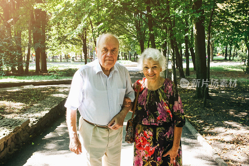 漂亮的老夫妇正在公园里散步。奶奶和爷爷在户外拥抱。金婚纪念日快乐。奶奶和爷爷的浪漫照片。真正的爱。