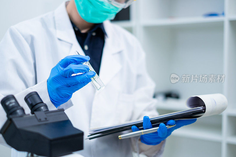 一个科学家在实验室里拿着一个化学物质或液体管。检验生物技术和医学研究、检验、检验或发现样品液质量的概念。
