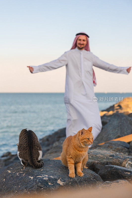 年轻的酋长在海边与流浪猫合影