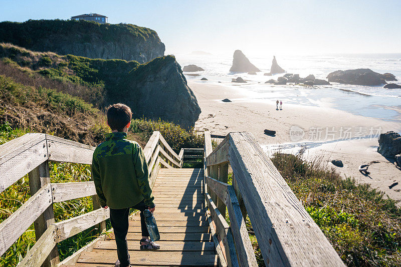 俄勒冈州，男孩走下台阶走向海滩