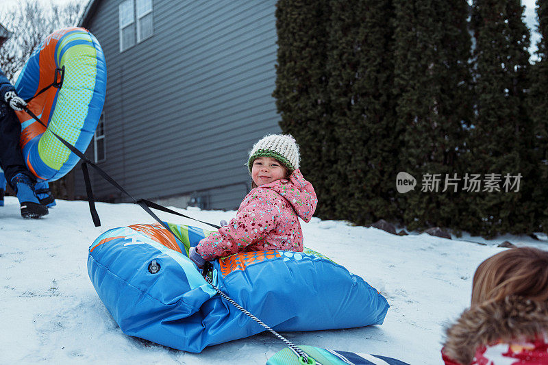 年轻的女孩从雪山上滑下