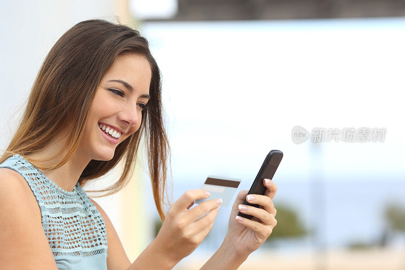 用智能手机在网上购物的快乐女人