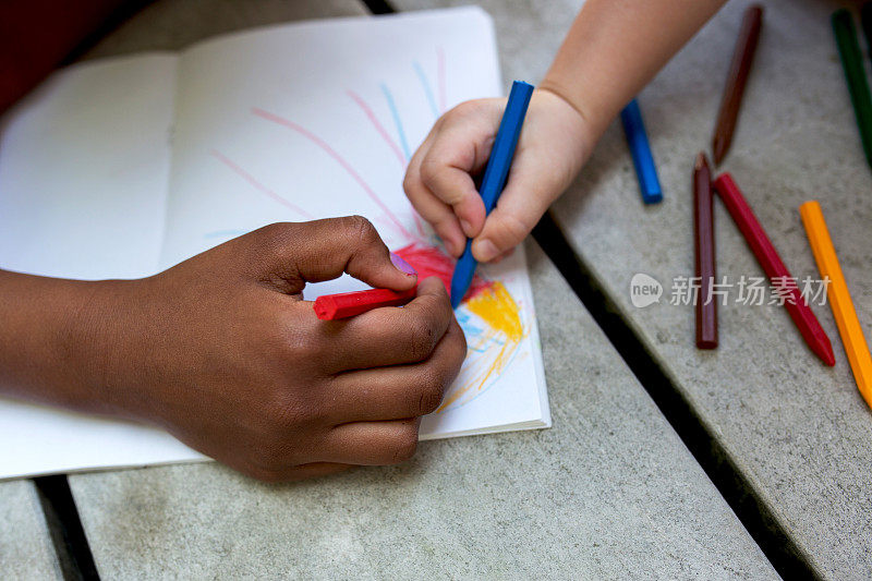 创意儿童的手在纸上画画。