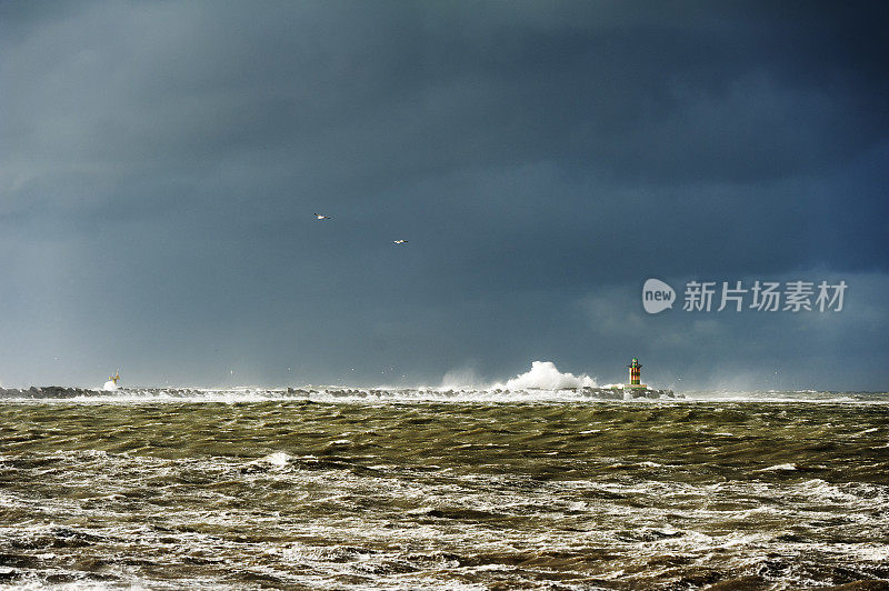 在暴风雨中非常狂暴的溅起浪花的灯塔