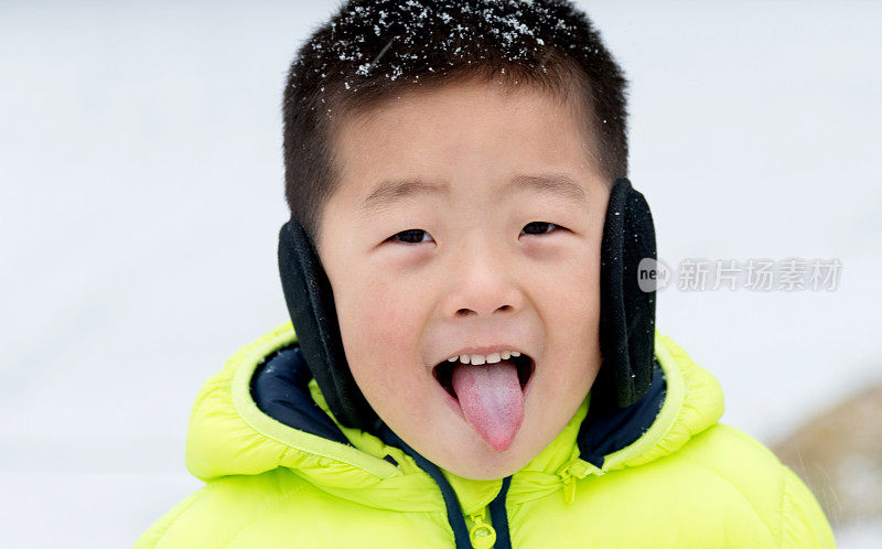 一个亚洲男孩在雪地里玩